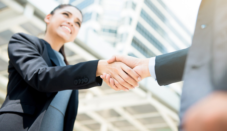 Businesswoman making handshake with a businessman - female leader concept