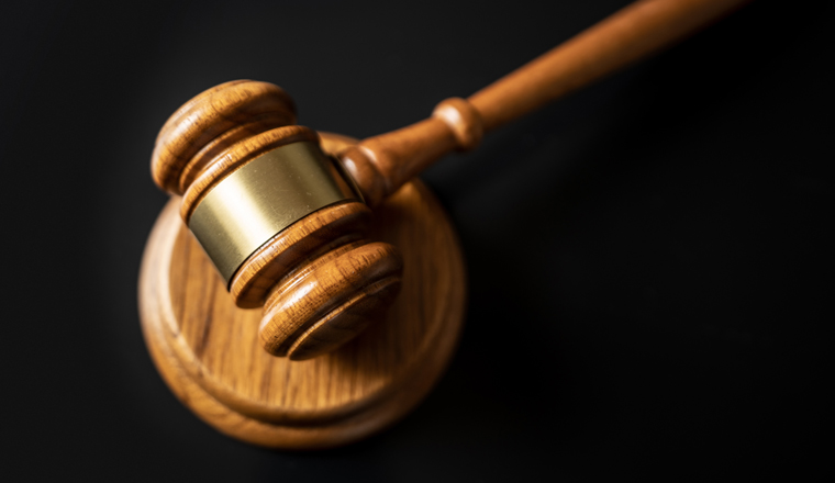 judge or auction Gavel on a wood block in courtroom, dark background