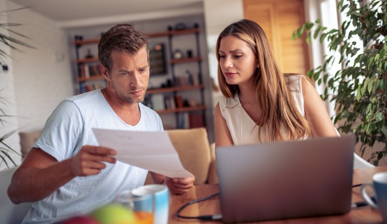 Young couple calculating their domestic budget together at home.