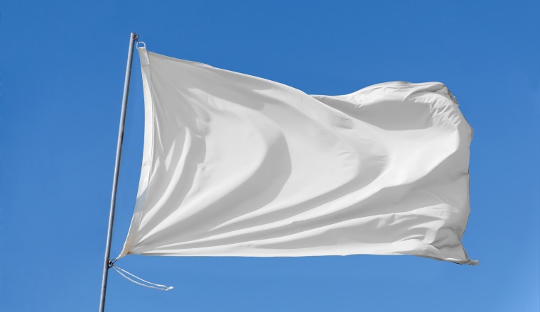 White flag attached to a flagpole waving on the sky