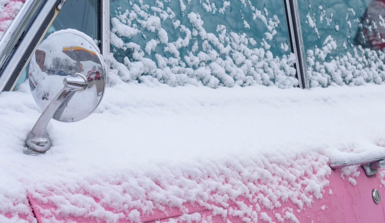 Vintage pink car covered in snow