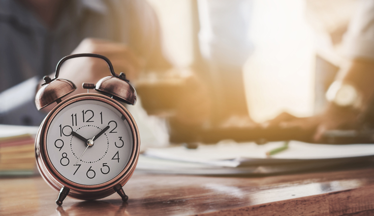 Desktop clock works with the background of a business meeting.