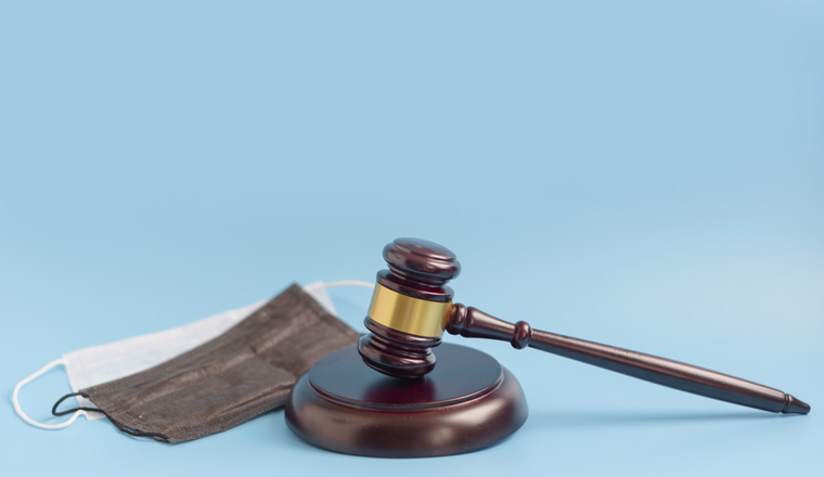  brown gavel and medical protective masks on a blue background
