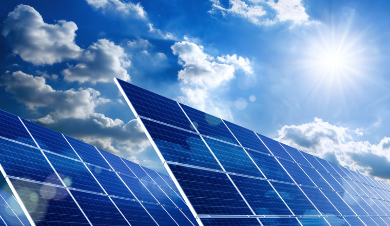 Two large solar panels under the blue sky with the sun and clouds