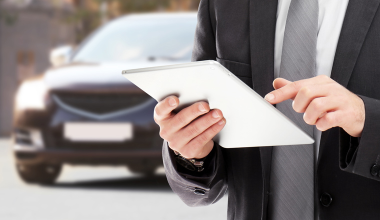 Insurance agent using tablet and car on background