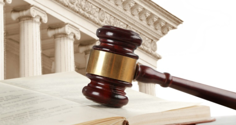 Judge's gavel with book and courthouse on background. Concept of law
